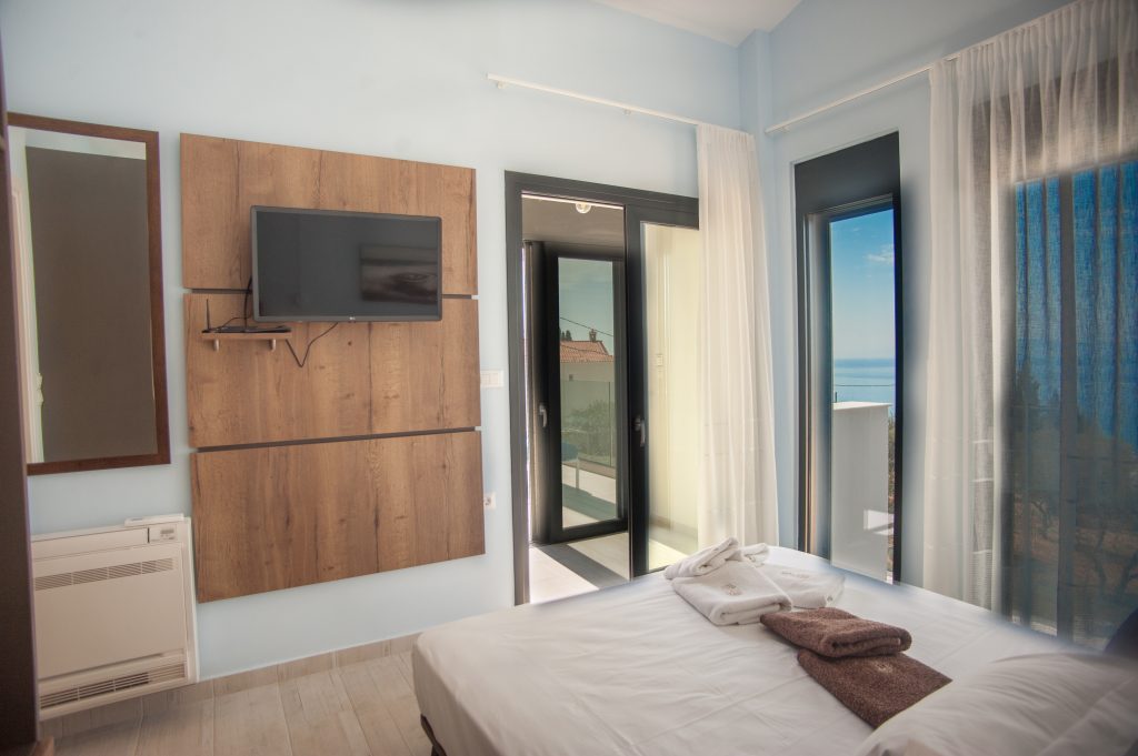 Villa Azzurro bedroom with wall-mounted TV and terrace access, Kefalonia