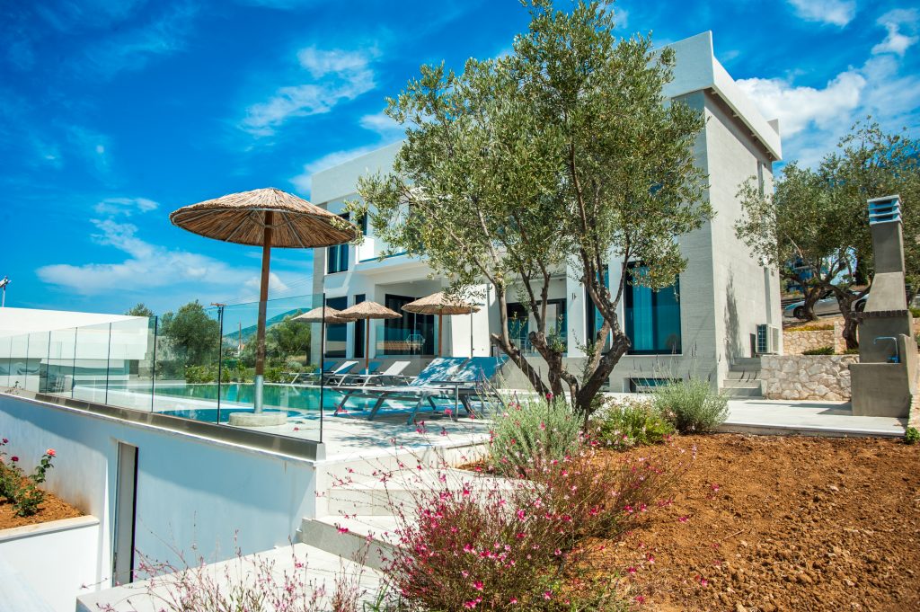 Villa Azzurro pool and villa exterior framed by olive trees, Kefalonia