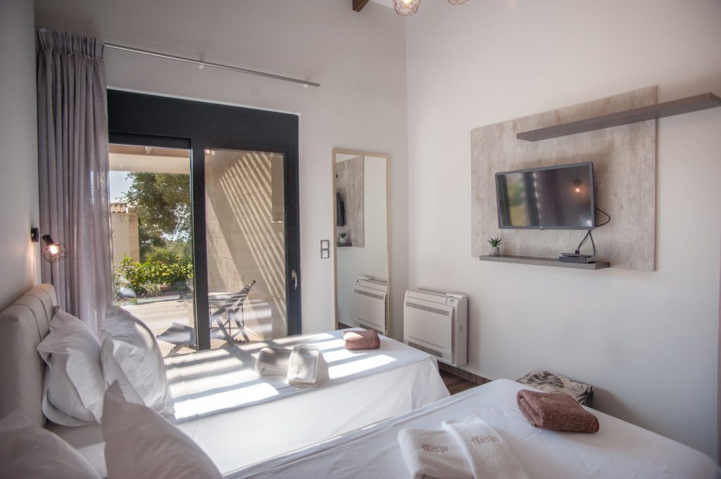 Villa Carisma bedroom with terrace access and wall-mounted TV, Kefalonia