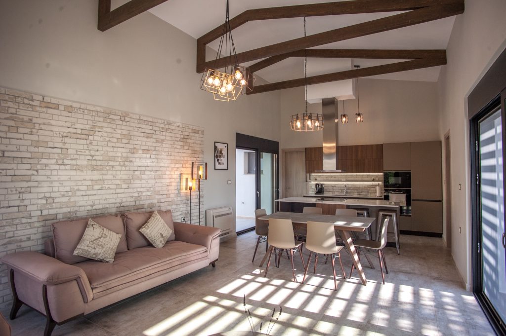Villa Carisma open-plan living area with sofa and exposed beams, Kefalonia