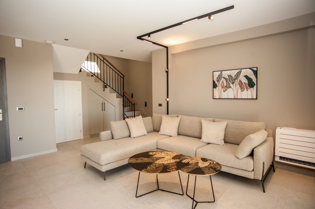 Villa Insieme open-plan living area with corner sofa and staircase, Kefalonia