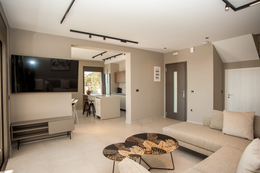 Villa Insieme open-plan living area with sofa and wall-mounted TV, Kefalonia