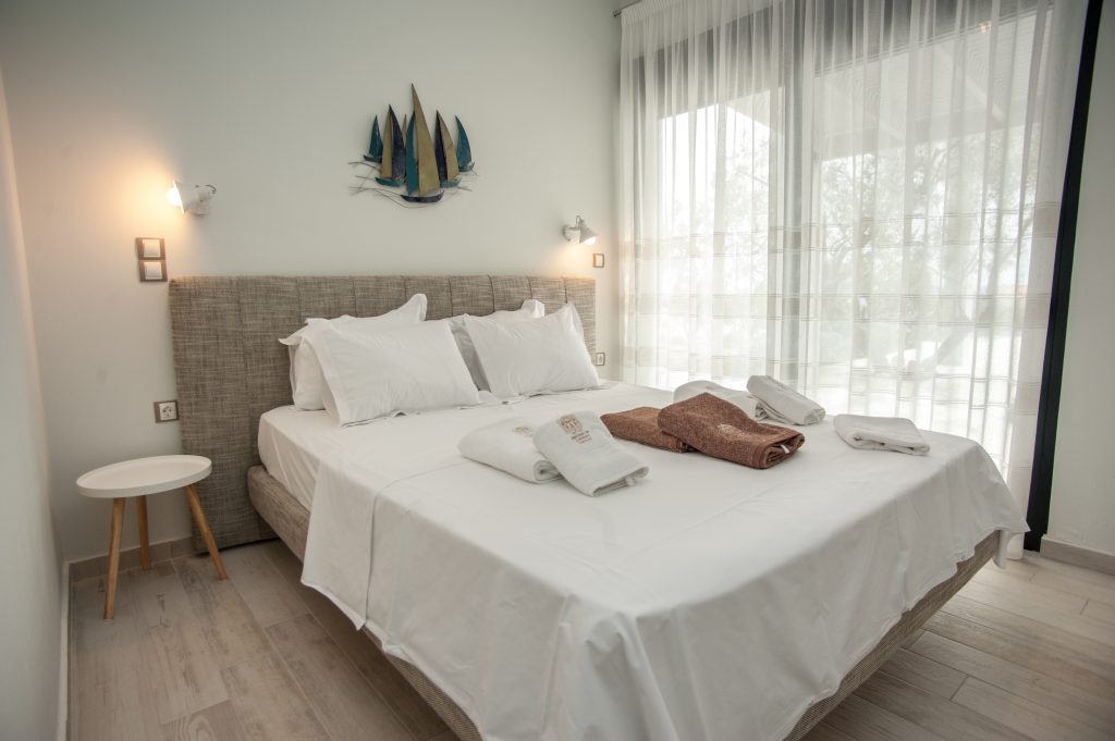 Villa Bambola bedroom with fitted headboard and folded towels, Kefalonia