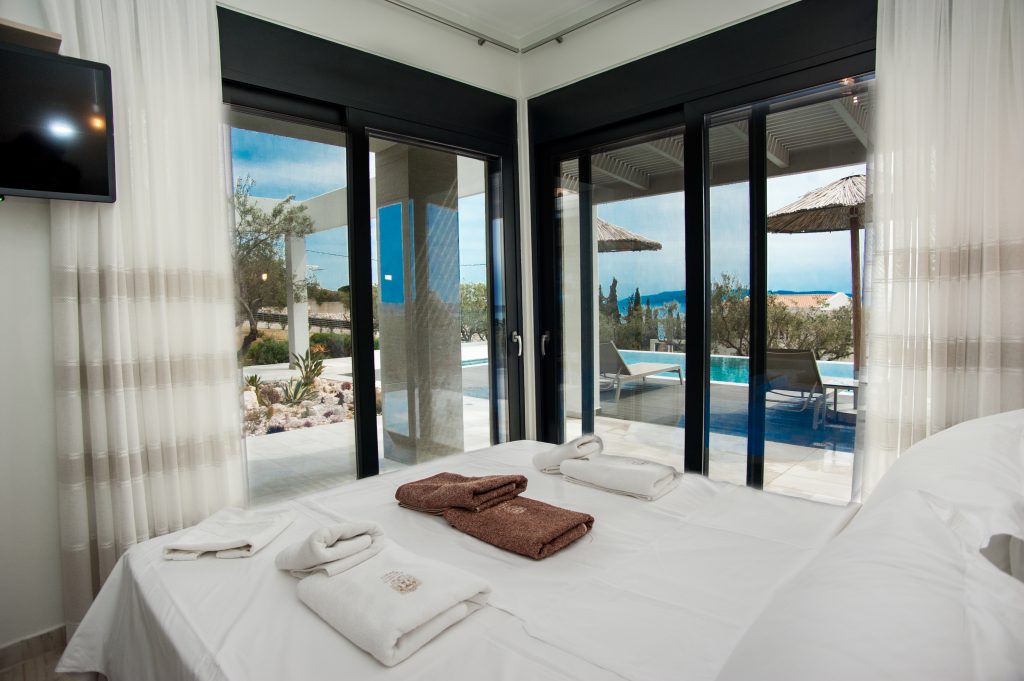 Villa Bambola bedroom with terrace doors onto the pool area, Kefalonia